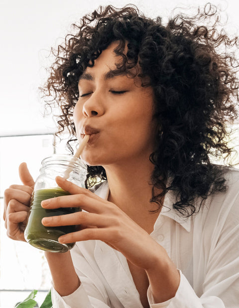 Woman enjoying drinking a green juice