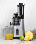 Juicer on counter with fruit and juice